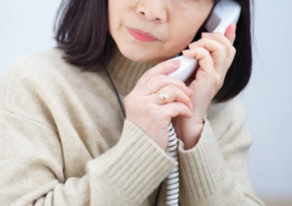 女性が愛典福島家に電話している写真